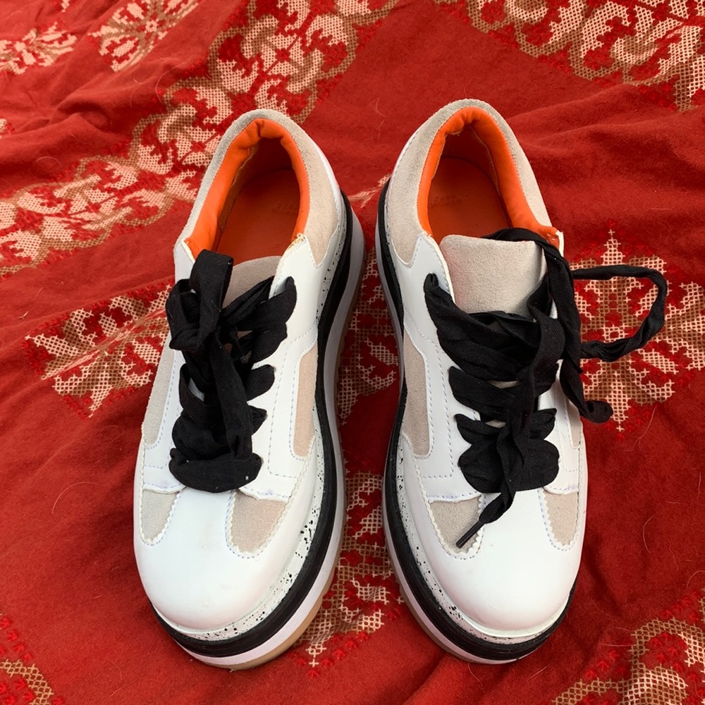Beautiful white beige with black laces sports tennis shoes very fancy.